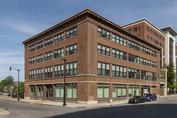 Historic brick corner building with large storefront windows